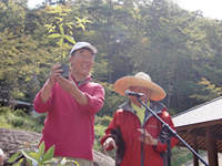 苗を掲げる遠藤雄幸市長（左側）